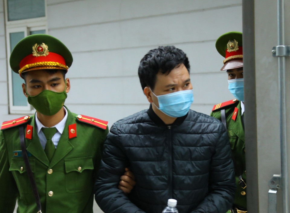 Cảnh sát dẫn giải các bị cáo đến tòa. (Ảnh: TTXVN)