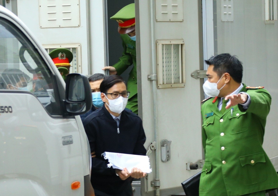 Cảnh sát dẫn giải bị cáo Nguyễn Văn Tứ (sinh năm 1965, cựu Chánh Văn phòng Thành ủy Hà Nội, cựu Giám đốc Sở Kế hoạch và Đầu tư thành phố Hà Nội) đến tòa. (Ảnh: TTXVN)