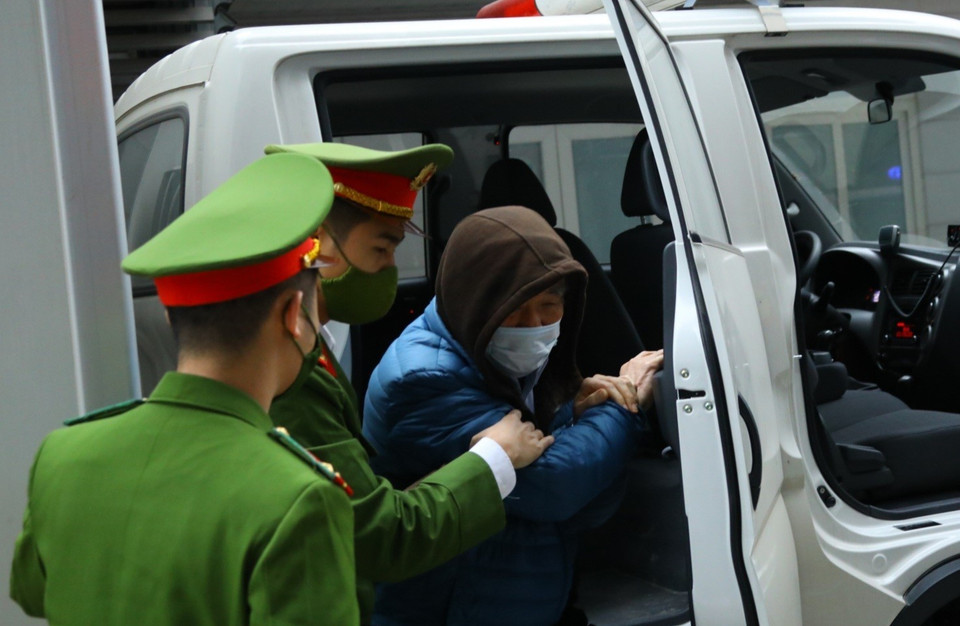 Hình ảnh cảnh sát dẫn giải các bị cáo đến tòa. (Ảnh: TTXVN)