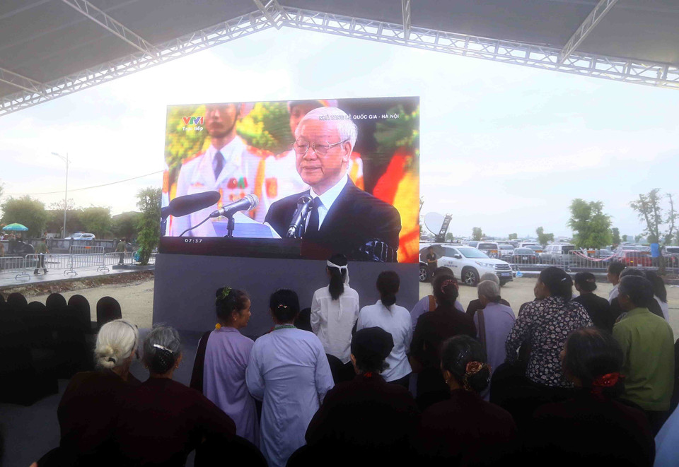 Người dân theo dõi Lễ Truy điệu Chủ tịch nước Trần Đại Quang qua màn hình lớn tại xã Quang Thiện, huyện Kim Sơn, tỉnh Ninh Bình. (Ảnh: TTXVN)