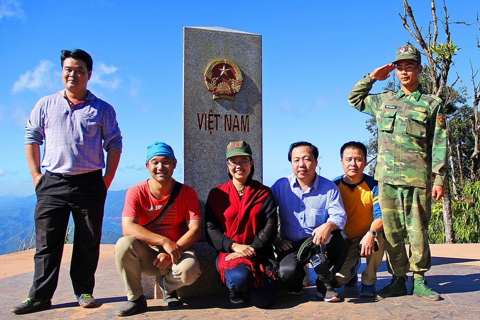 Du khách chụp ảnh kỷ niệm bên cột mốc số 0. (Ảnh: Phan Tuấn Anh/TTXVN)