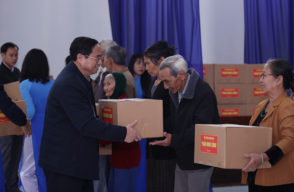 Thủ tướng Phạm Minh Chính tặng quà các hộ dân thuộc diện giải phóng mặt bằng của dự án tuyến đường cao tốc Bắc-Nam phía Đông. (Ảnh: Dương Giang/TTXVN)