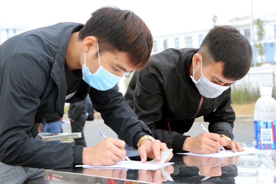 Những người rời Quảng Ninh thực hiện khai báo y tế tại trạm kiểm soát dịch bệnh COVID-19 cầu Bạch Đằng (Quảng Yên, Quảng Ninh). (Ảnh: Văn Đức/TTXVN)