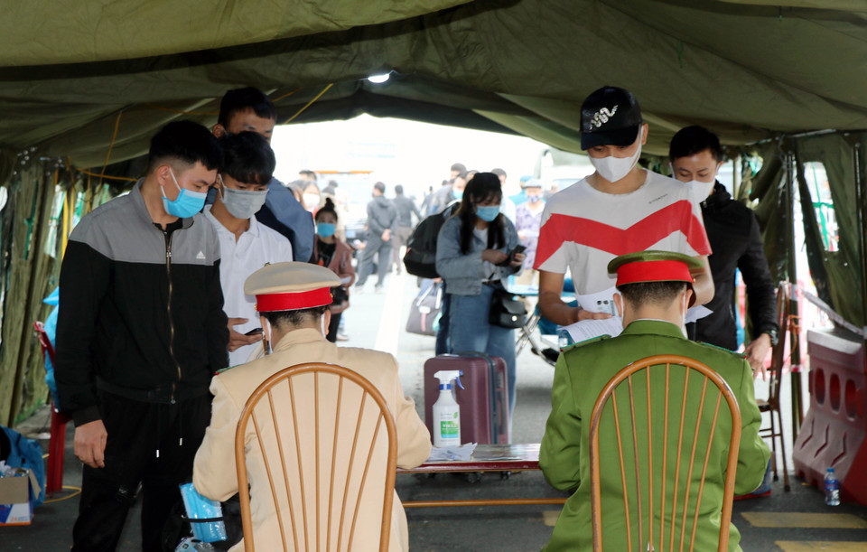 Những người rời Quảng Ninh thực hiện khai báo y tế tại trạm kiểm soát dịch bệnh COVID-19 cầu Bạch Đằng (Quảng Yên, Quảng Ninh). (Ảnh: Văn Đức/TTXVN)