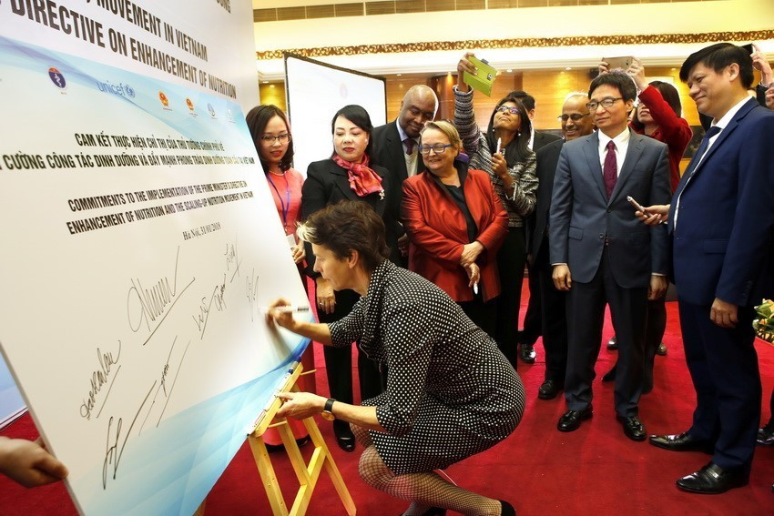 Việt Nam cam kết đẩy mạnh hơn nữa việc thực hiện các Mục tiêu phát triển bền vững, chú trọng các chính sách giảm nghèo bền vững, thu hẹp khoảng cách phát triển giữa các khu vực địa lý, các nhóm dân cư, trong đó đặc biệt chú trọng các nhóm dễ bị tổn thương. Trong ảnh: Các đại biểu ký cam kết hưởng ứng Lễ phát động Phong trào đẩy mạnh dinh dưỡng toàn cầu tại Việt Nam do Bộ Y tế và Quỹ Nhi đồng Liên Hiệp quốc phối hợp tổ chức. (Ảnh; Dương Ngọc/TTXVN)