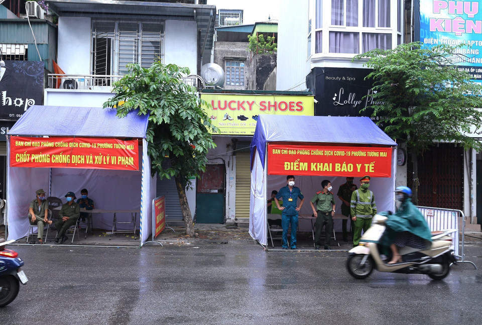 Lực lượng an ninh tại điểm chốt Trương Định (Hoàng Mai) tạm thời không kiểm tra giấy đi đường của người dân do mưa lớn. (Ảnh: Hoàng Hiếu/TTXVN)