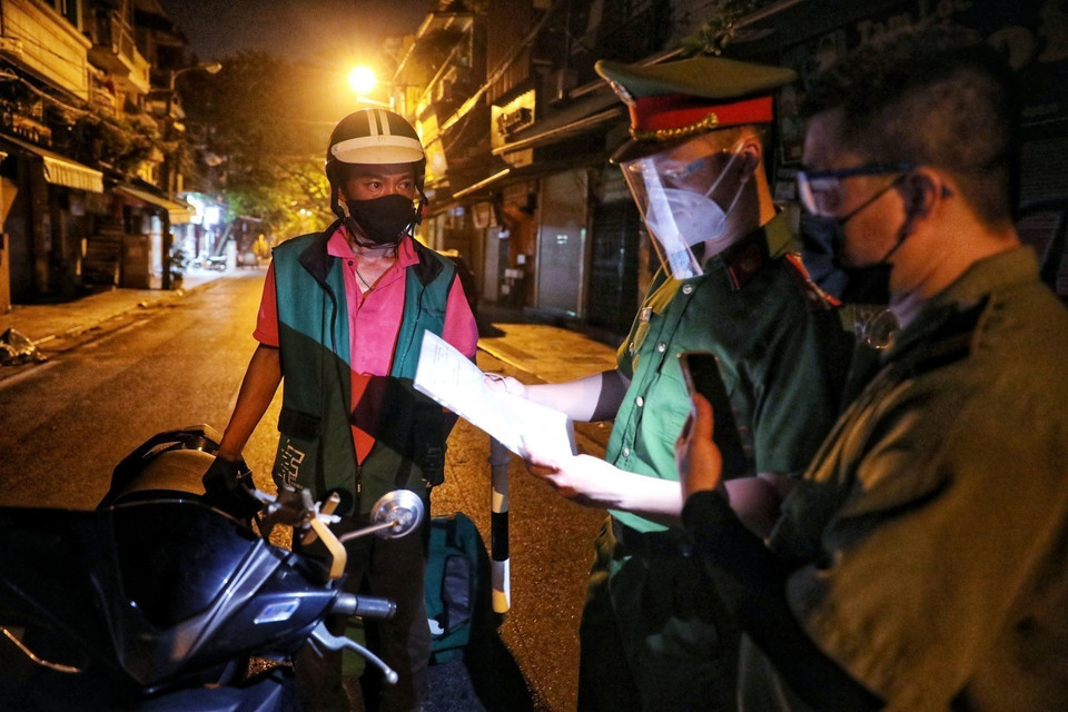 Lực lượng chức năng phường Hàng Buồm kiểm soát chặt chẽ người qua chốt. Những ai không có giấy đi đường theo quy định mới đều được yêu cầu quay đầu xe. (Ảnh: Thành Đạt/TTXVN)