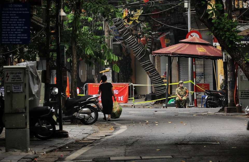 Tại chốt kiểm soát phường Hàng Buồm, người dân ngoài giấy đi đường còn phải xuất trình một số giấy tờ cá nhân khác như: CCCD/CMTND, lịch trực, lịch làm việc, văn bản phân công nhiệm vụ của cơ quan, đơn vị. (Ảnh: Thành Đạt/TTXVN)