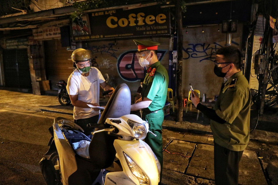 Tại các chốt kiểm soát COVID-19 trên khu phố cổ, lực lượng chức năng làm việc xuyên đêm để đảm bảo công tác phòng, chống dịch. (Ảnh: Thành Đạt/TTXVN)