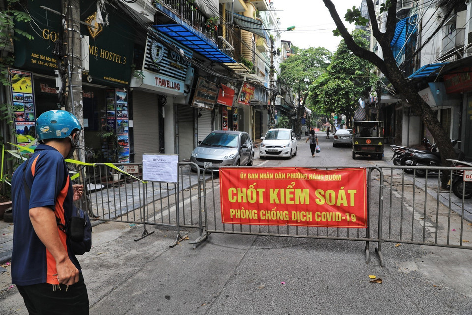 Phố Mã Mây lập "chốt cứng" cả 2 đầu phố để không cho người lạ, khách vãng lai đi vào, đồng thời dán thông báo người dân đi vòng đường khác qua chốt "mềm" để lực lượng chức năng kiểm tra giấy tờ. (Ảnh: Thành Đạt/TTXVN)