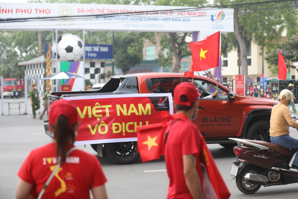 Cổ động viên và ôtô cùng một màu cờ Tổ quốc trước trận đấu đầu tiên tại SEA Games 31 của U23 Việt Nam. (Ảnh: Minh Quyết/TTXVN)