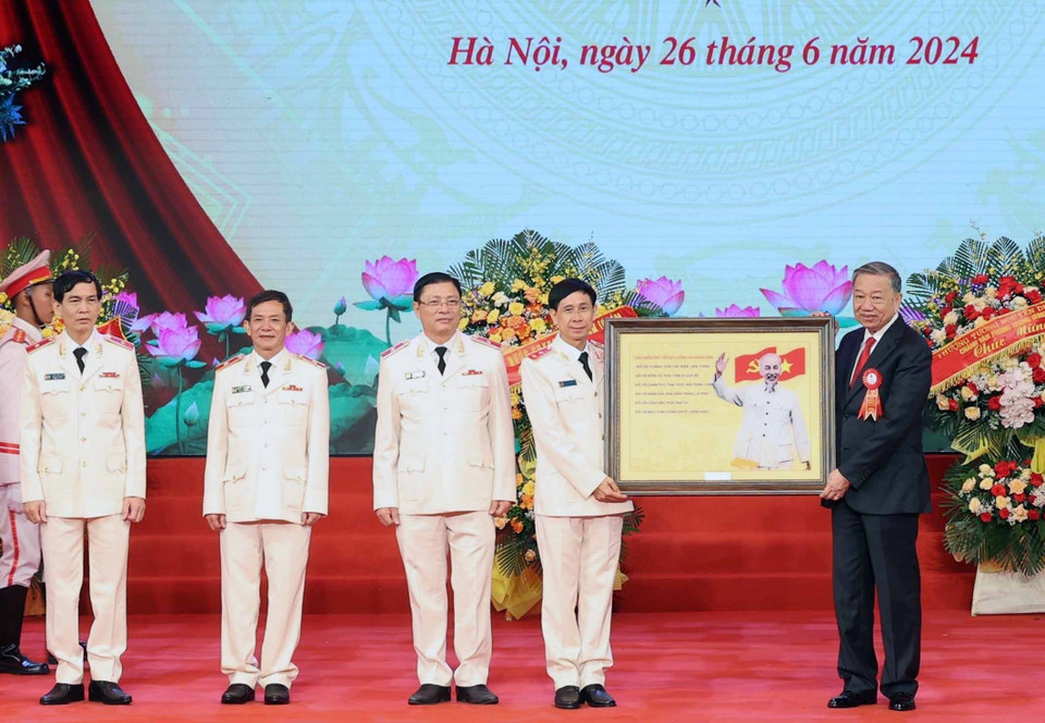 Chủ tịch nước Tô Lâm tặng chân dung Chủ tịch Hồ Chí Minh cho Lực lượng kỹ thuật nghiệp vụ Công an nhân dân. (Ảnh: Nhan Sáng/TTXVN)