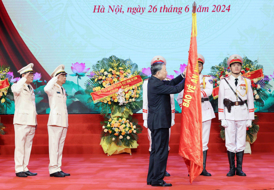 Chủ tịch nước Tô Lâm gắn Huân chương Chiến công hạng Nhì lên cờ truyền thống của Lực lượng kỹ thuật nghiệp vụ Công an nhân dân. (Ảnh: Nhan Sáng/TTXVN)