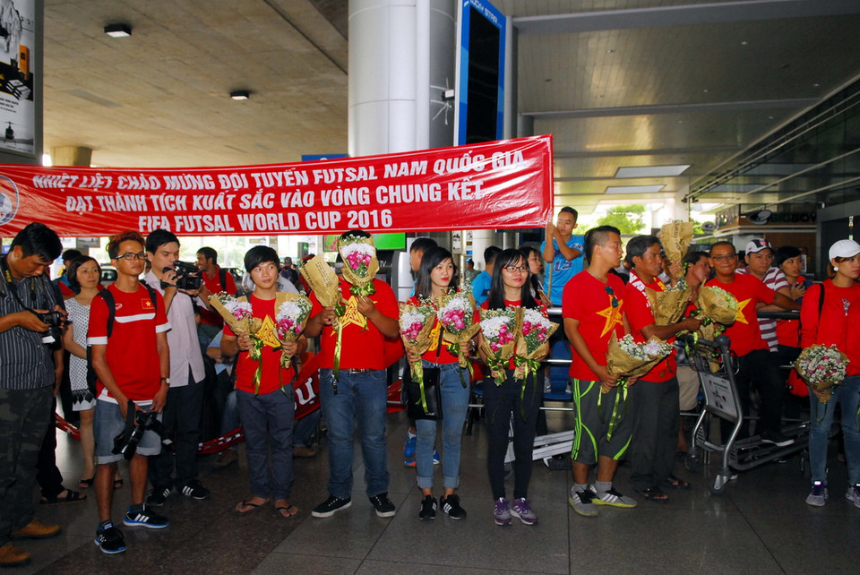 Người hâm mộ chào đón và tặng hoa cho đội tuyển futsal Việt Nam. (Ảnh: Mạnh Linh/TTXVN)