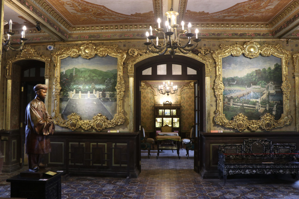 Những bức tranh khổ lớn miêu tả lăng tẩm của các vị vua nhà Nguyễn được trang trí trong Cung An Định. (Ảnh: Đỗ Trưởng/TTXVN)