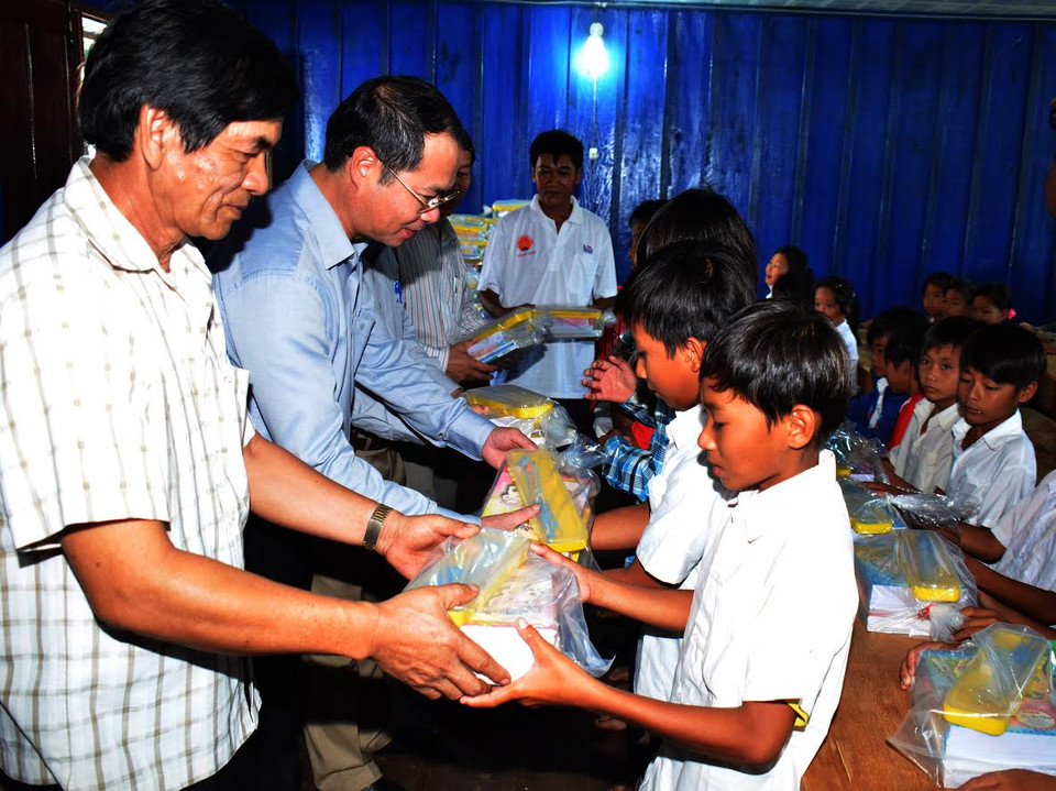 Các đại biểu trao quà tặng cho các học sinh con em kiều bào. (Nguyễn Lâm/Vietnam+)