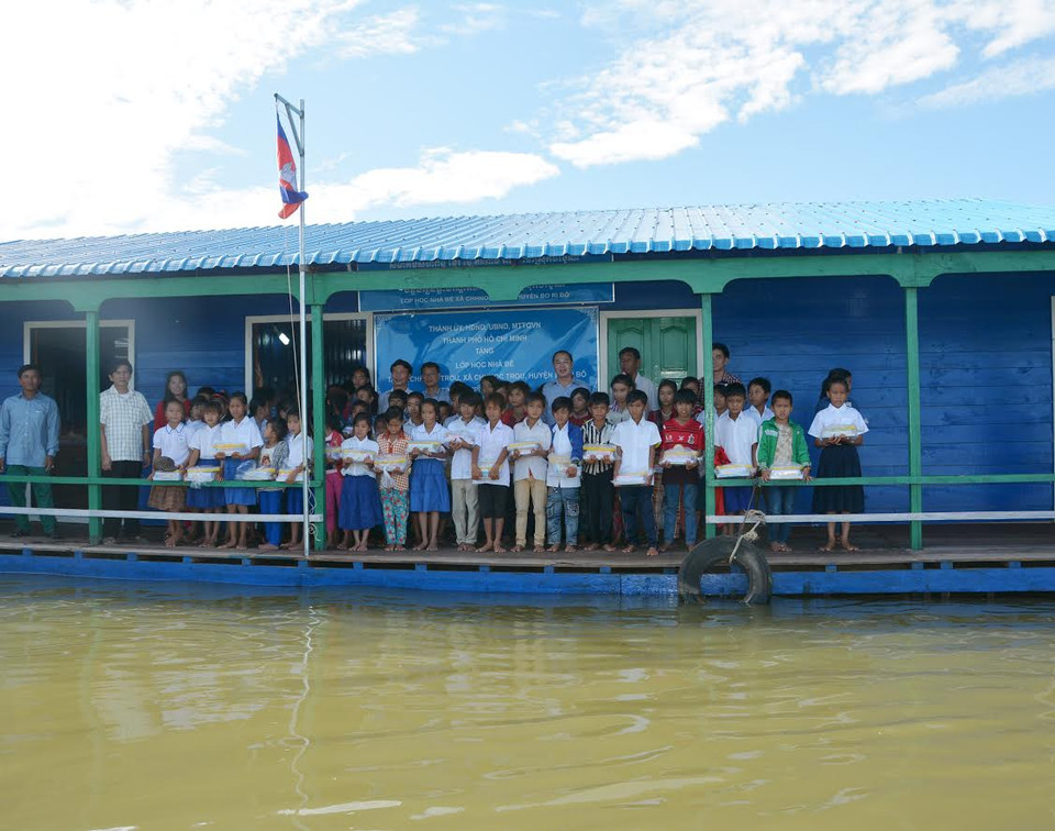 Các em học sinh kiều bào tại ngôi trường nổi tiễn chào đoàn công tác. (Nguyễn Lâm/Vietnam+)