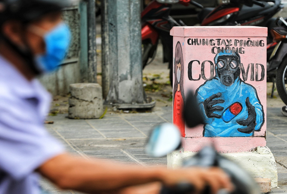 Việc đưa những bức tranh cổ động, tuyên truyền lên các bốt điện đã được thực hiện trong vòng nửa tháng qua, và điều này đã khiến người dân quanh khu vực ngã 4 Bạch Mai - Lê Thanh Nghị phần nào ý thức hơn trong việc phòng dịch. (Ảnh: Thành Đạt/TTXVN)