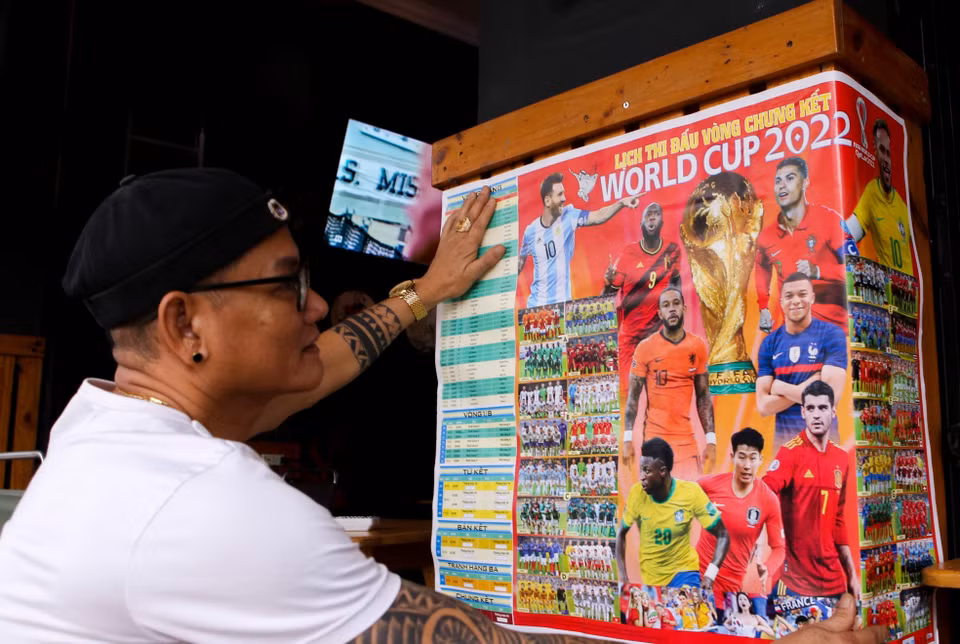 Lịch thi đấu World Cup 2022 được dán ngay trước các quán càphê để người hâm mộ tiện theo dõi các trận bóng đá. (Ảnh: Trần Lê Lâm/TTXVN)