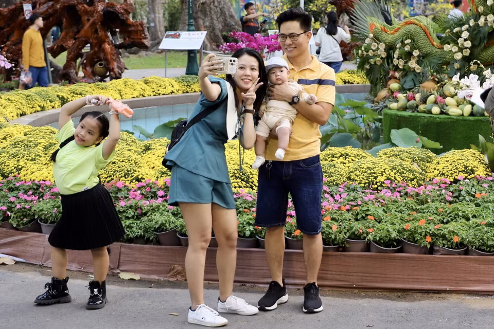 Người dân, du khách chụp ảnh tại các công trình nghệ thuật của Hội Hoa Xuân. (Ảnh: Hồng Giang/TTXVN)