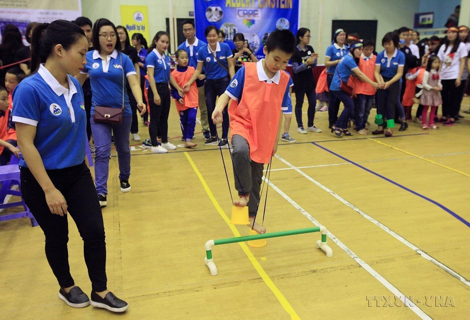 Trẻ tự kỷ tham gia trò chơi thi đi cà kheo hộp tại chương trình Thể thao thân thiện, do Mạng lưới Người tự kỷ Việt Nam chủ trì tổ chức (2/4/2016). (Ảnh: Anh Tuấn/TTXVN)