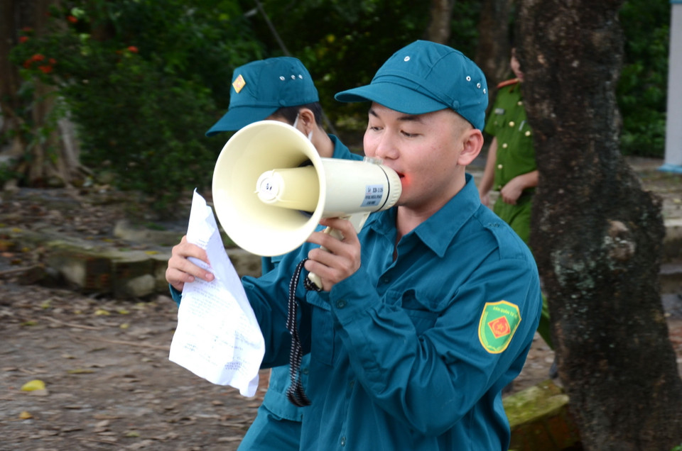Lực lượng chức năng kêu gọi, vận động người dân trong khu vực nguy hiểm nhanh chóng di dời tránh bão số 9. (Ảnh: Quốc Dũng/TTXVN)