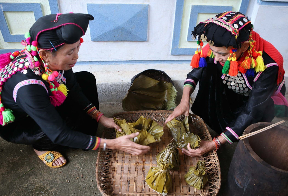 Phụ nữ dân tộc Si La chuẩn bị các lễ vật để cúng tổ tiên và thần linh. (Ảnh: Quý Trung/TTXVN)