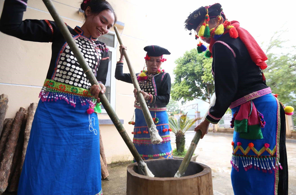 Phụ nữ dân tộc Si La giã bánh giầy. (Ảnh: Quý Trung/TTXVN)