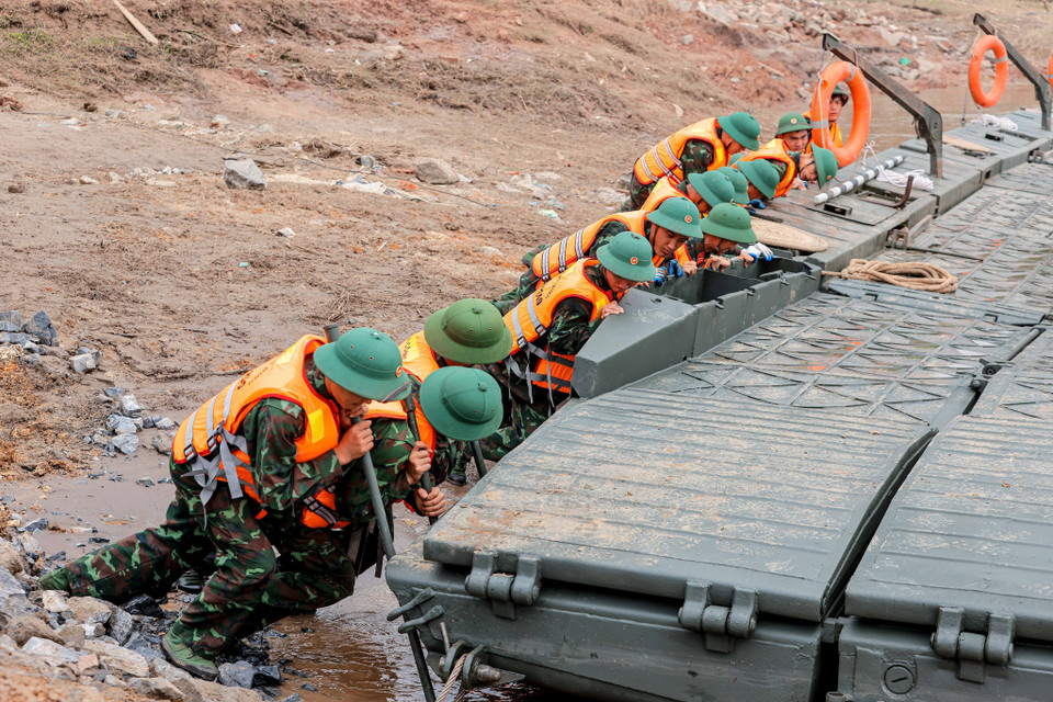 Cùng hợp sức đưa cầu phao ra khơi, di chuyển đến vị trí lắp đặt. (Ảnh: Hoàng Hiếu/TTXVN)