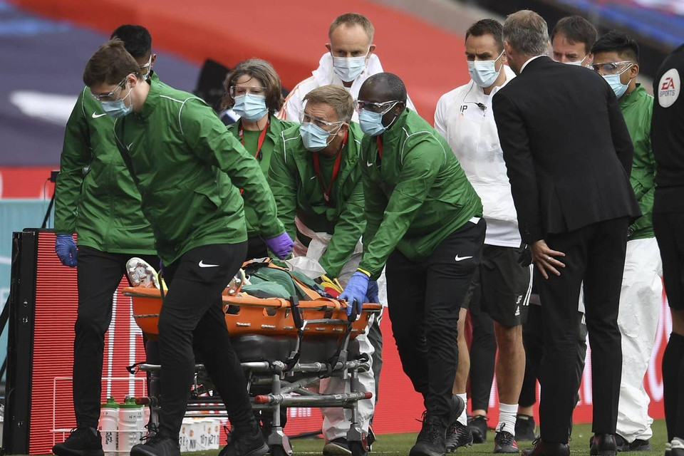 ...và phải rời sân bằng cáng.