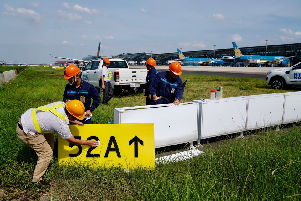 Nhân viên đội cơ điện dèn khu bay đang thực hiện bảo trì hệ thống biện báo. (Ảnh: Văn phòng NIA)