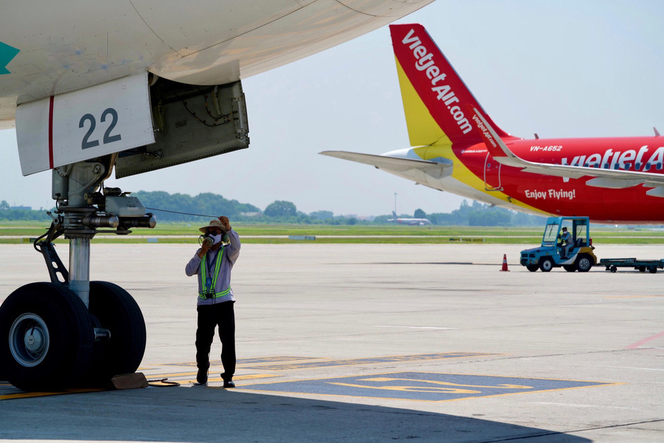 Một nhân viên tranh thủ nghỉ ngơi ngay dưới bóng râm ít ỏi của phương tiện. (Ảnh: Văn phòng NIA)