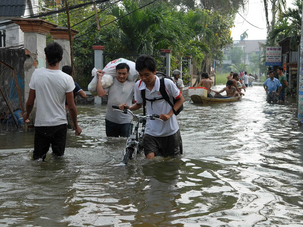 Người dân chuyển đồ đạc đến khu vực cao. (Ảnh: Mạnh Linh/TTXVN)