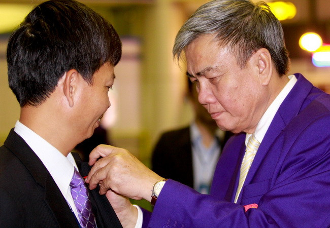 Ông Lâm Quang Thành trao huy hiệu danh dự cho phó tổng giám đốc Trịnh Ngọc Thành. (Ảnh: Minh Chiến/Vietnam+)