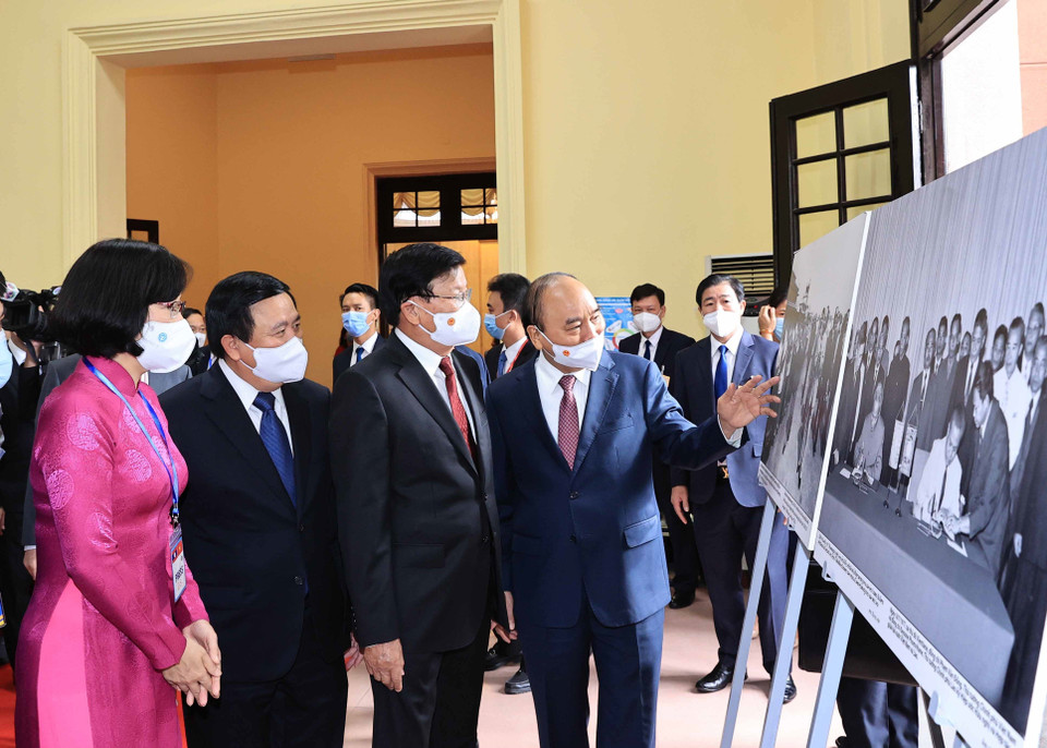 Phó Tổng Giám đốc Thông tấn xã Việt Nam Vũ Việt Trang giới thiệu trưng bày ảnh của TTXVN với Tổng Bí thư, Chủ tịch nước Lào Thongloun Sisoulith và Chủ tịch nước Nguyễn Xuân Phúc. (Ảnh: Thống Nhất/TTXVN)