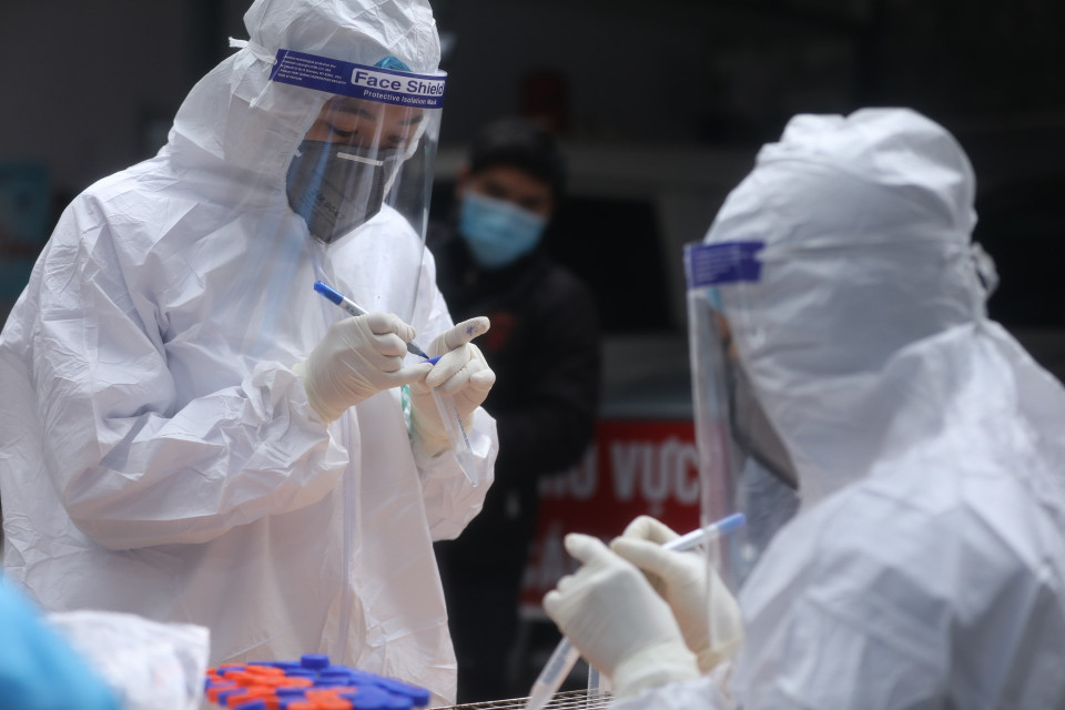 Nhân viên y tế quận Hai Bà Trưng chuẩn bị dụng cụ lấy mẫu cho người dân về từ vùng dịch. (Ảnh: Minh Quyết/TTXVN)