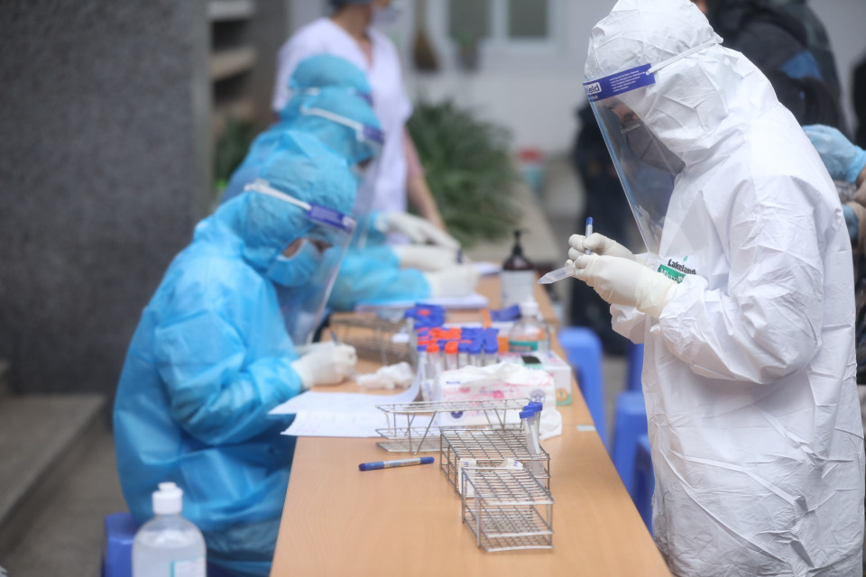 Nhân viên y tế quận Hai Bà Trưng chuẩn bị dụng cụ lấy mẫu cho người dân về từ vùng dịch. (Ảnh: Minh Quyết/TTXVN)