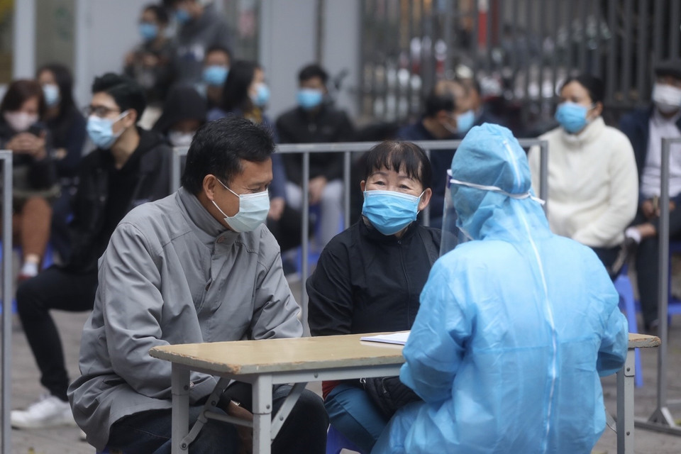 Nhân viên y tế quận Hai Bà Trưng chuẩn bị dụng cụ lấy mẫu cho người dân về từ vùng dịch. (Ảnh: Minh Quyết/TTXVN)