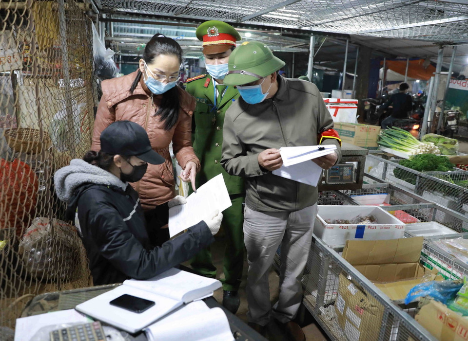 Các lực lượng chức năng và Ban Quản lý chợ, tuyên truyền việc chấp hành quy định về phòng chống dịch bệnh, đến với các tiểu thương và người dân mua sắm tại chợ. (Ảnh: Vũ Sinh/TTXVN)