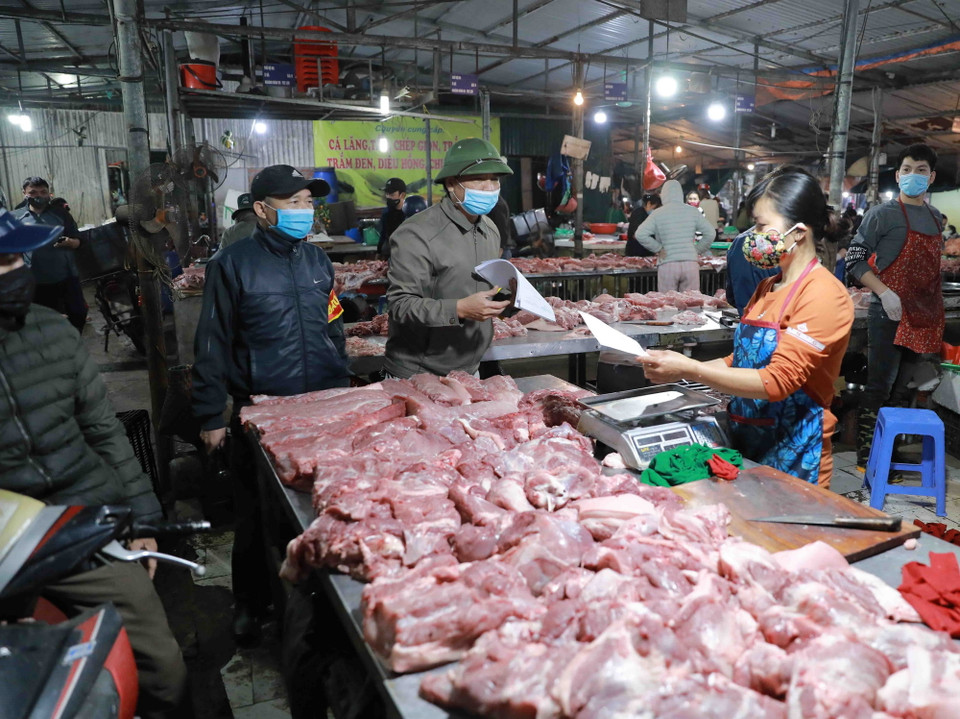 Các lực lượng chức năng và Ban Quản lý chợ, tuyên truyền việc chấp hành quy định về phòng chống dịch bệnh, đến với các tiểu thương và người dân mua sắm tại chợ. (Ảnh: Vũ Sinh/TTXVN)