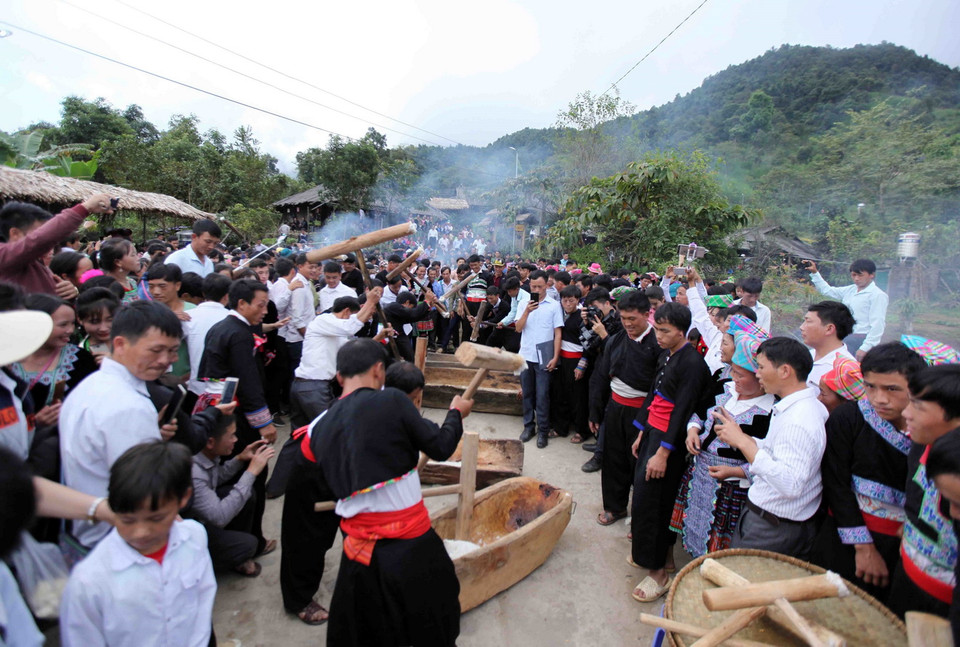 Các thành viên của các đội tập trung giã bánh giầy thật nhanh cho bánh có độ kết dính dẻo.(Ảnh: Quý Trung/TTXVN)