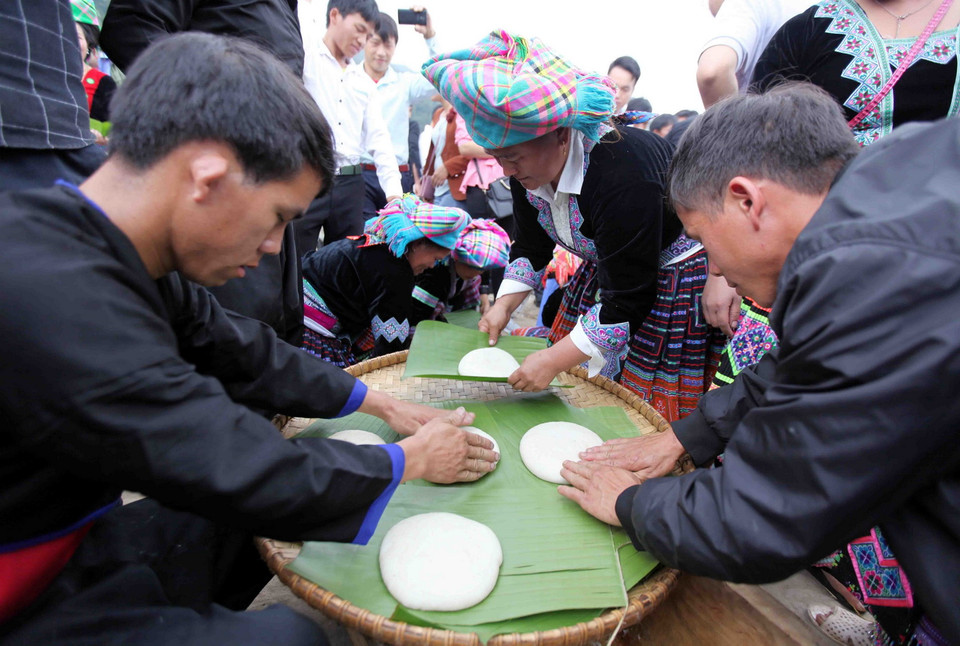 Các đội tập trung nặn những chiếc bánh giầy vừa tròn vừa đẹp. (Ảnh: Quý Trung/TTXVN)