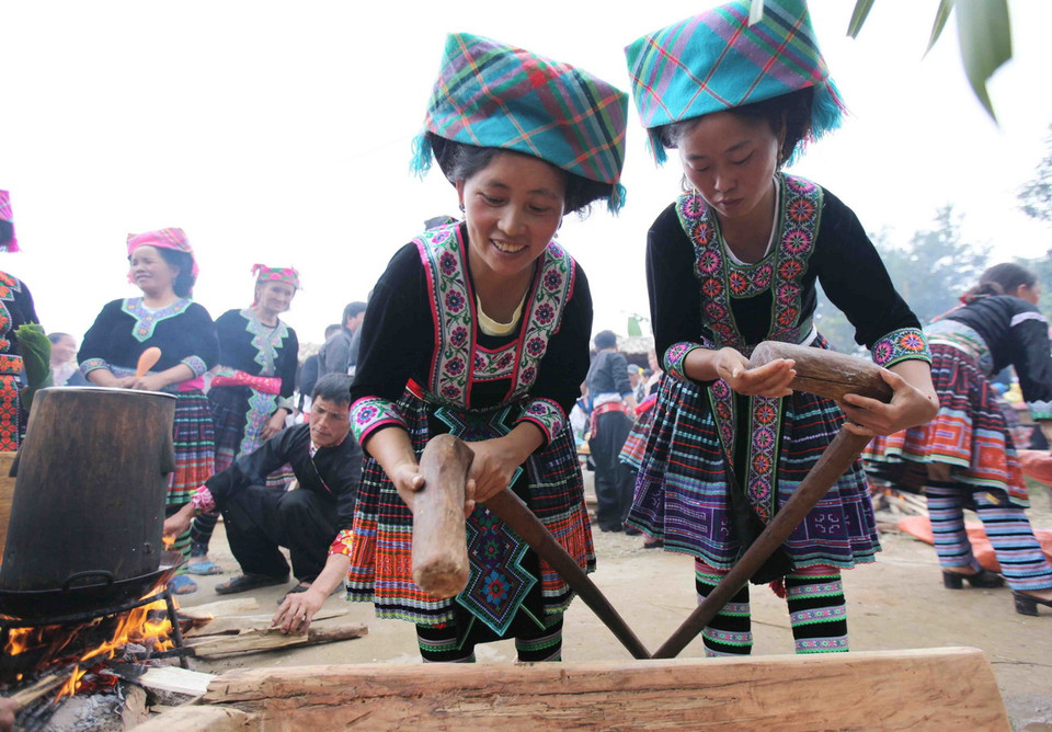 Các chị em lấy lòng đỏ trứng gà xoa đều vào các vật dụng để khi giã bánh giầy không bị dính và nhanh nhất lại đẹp. (Ảnh: Quý Trung/TTXVN)