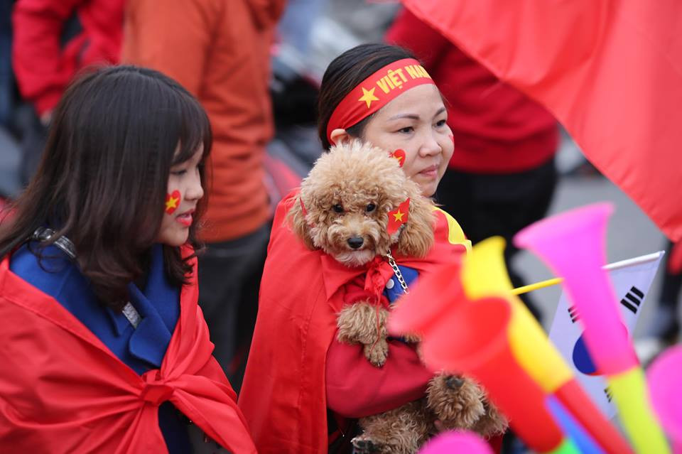 Hai mẹ con bế cả chú thú cưng đi để cổ vũ đội tuyển Việt Nam. (Ảnh: Minh Sơn/Vietnam+)