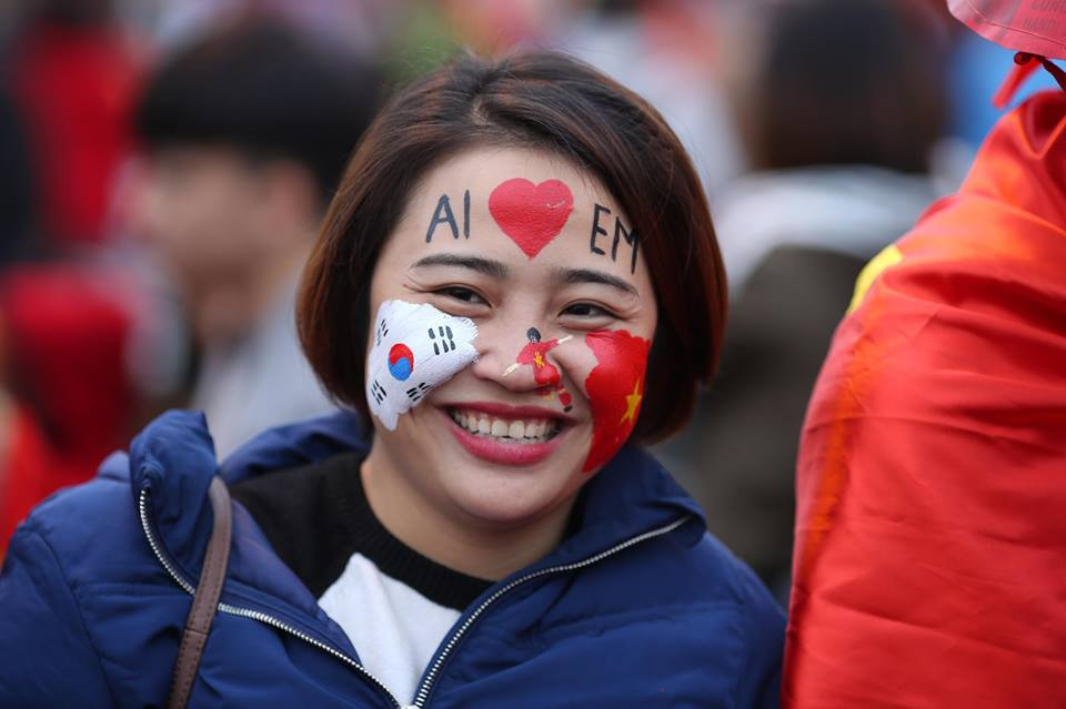 Tình đoàn kết, hữu nghị dân tộc Việt Nam và Hàn Quốc được cổ động viên dán băng rôn quốc kỳ lên má. (Ảnh: Minh Sơn/Vietnam+)