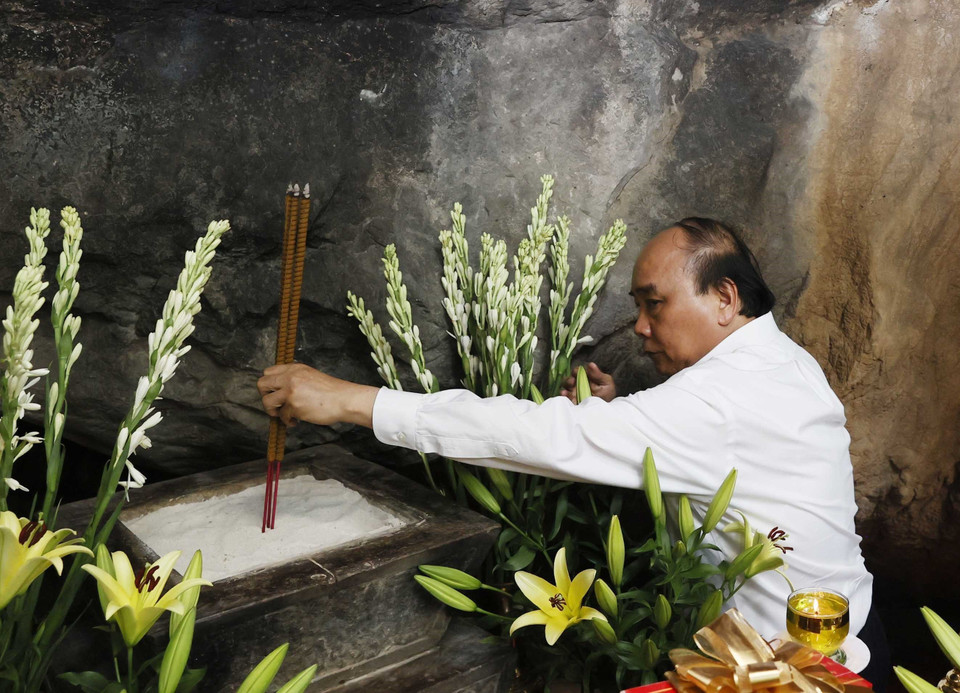 Chủ tịch nước Nguyễn Xuân Phúc dâng hương tại Hang 8 thanh niên xung phong nhân kỷ niệm 50 năm Ngày hy sinh các liệt sỹ Thanh niên xung phong tại đường 20 Quyết Thắng. (Ảnh: Thống Nhất/TTXVN)