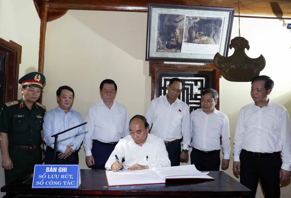 Chủ tịch nước Nguyễn Xuân Phúc ghi lưu bút tại Đền thờ Liệt sỹ Hang 8 thanh niên xung phong. (Ảnh: Thống Nhất/TTXVN)
