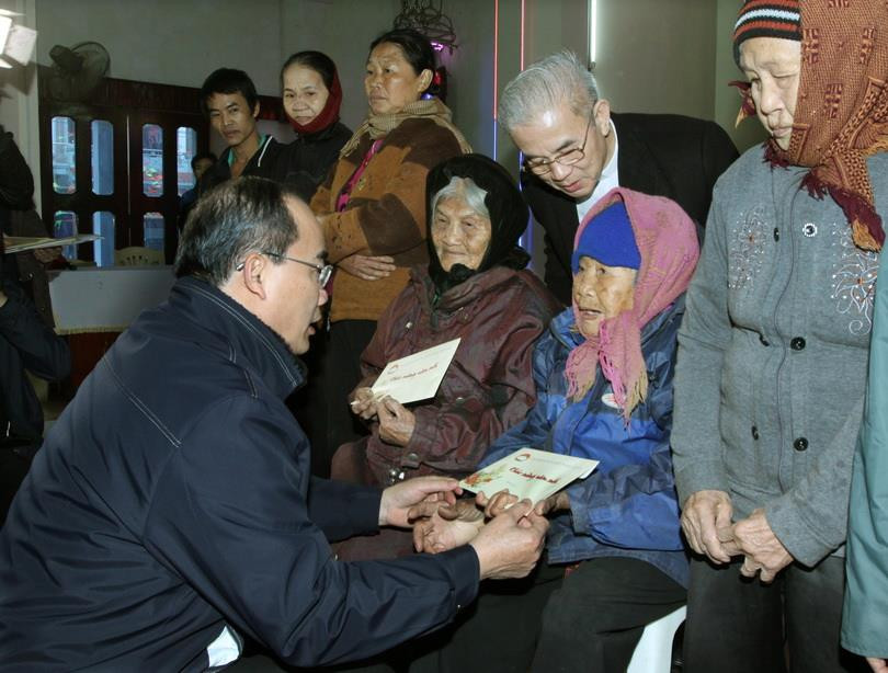 Chủ tịch UBTƯ MTTQ Việt Nam Nguyễn Thiện Nhân tặng quà, chúc mừng Năm mới Ất Mùi 2015 cho giáo dân nghèo ở Giáo xứ Điền Hộ, xã Nga Điền, huyện Nga Sơn, tỉnh Thanh Hóa. (Ảnh: Nguyễn Dân/TTXVN)