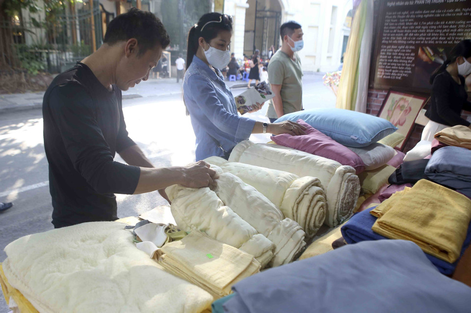 Khách tham quan gian hàng của làng dệt Phùng Xá. (Ảnh: Tuấn Đức/TTXVN)