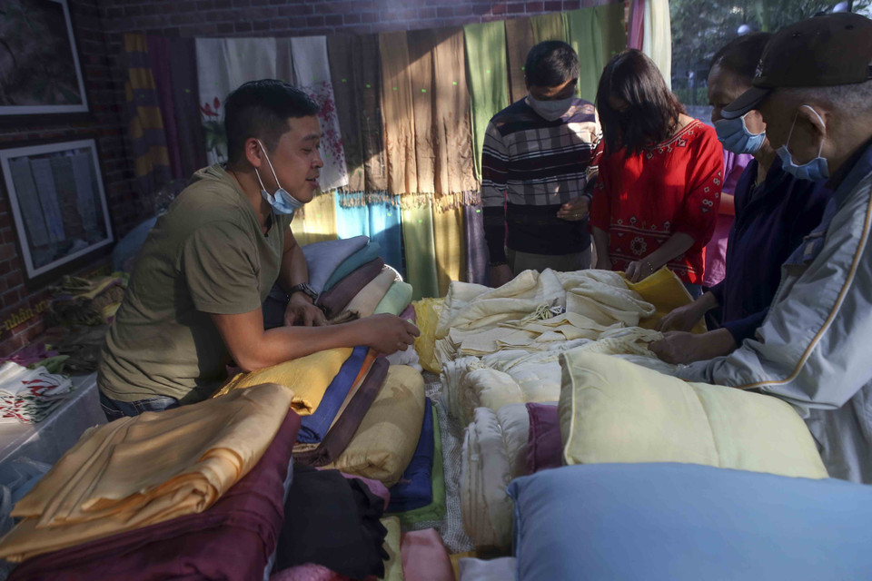 Khách tham quan gian hàng của làng dệt Phùng Xá. (Ảnh: Tuấn Đức/TTXVN)